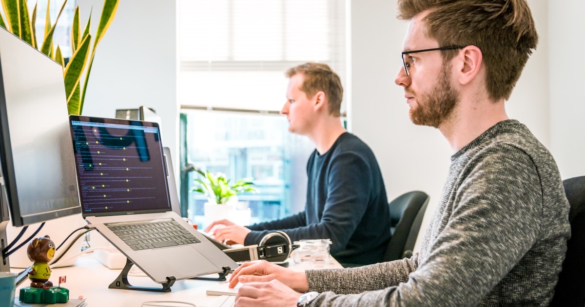 Overwhelmed professional surrounded by multiple screens and notifications